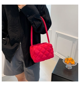 Detail view of quilted puffer bag in bright magenta featuring elegant diamond stitching