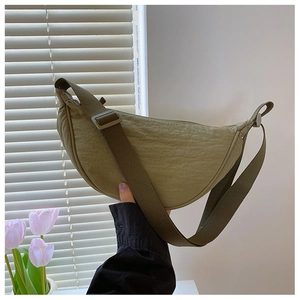 Detail of army green nylon dumpling bag with crinkled texture and wide shoulder strap