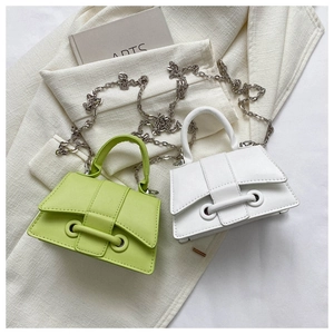 Detail of green and white mini trapezoid handbags with decorative bar and metal chain straps
