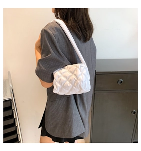 Detailed view of the white quilted nylon puffy shoulder bag texture and padded strap