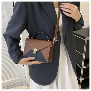 Detail of color-block envelope bag with gold twist lock and fine contrast stitching