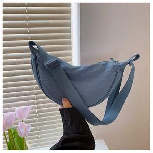 Detailed macro view of the blue nylon crescent bag with adjustable wide shoulder strap