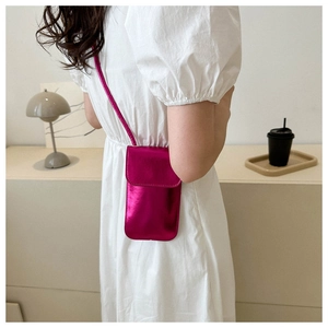 Mini sac bandoulière rose métallisé porté par un mannequin dans un cadre de vie moderne
