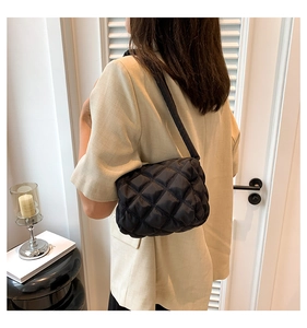 Close-up of a black quilted nylon shoulder bag showing a fluffy diamond texture