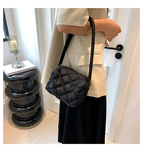 Close-up of black quilted nylon shoulder bag with elegant diamond lattice pattern