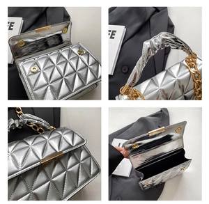 Detail of silver quilted handbag showing gold chain handle and metallic magnetic closure