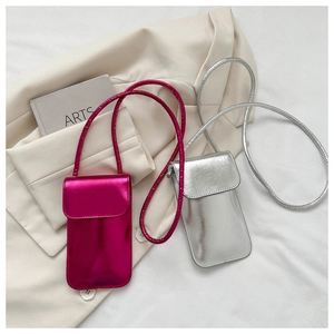 Sacs de téléphone brillants en argent et magenta présentés sur un blazer beige élégant