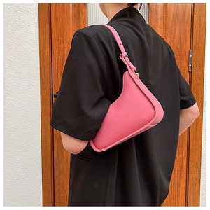 Detail showing the adjustable gold metal buckle and stitching on a pink shoulder bag