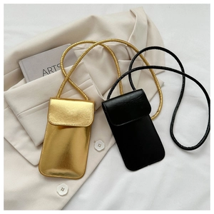 Détails de mini sacs pour téléphone dorés et noirs sur un blazer chic avec accessoires