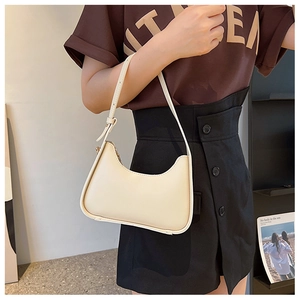 Close-up of cream PU leather underarm bag with adjustable strap and top zipper detail