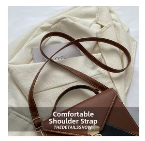 Detail of adjustable slim leather strap on brown patchwork bag with metal buckle