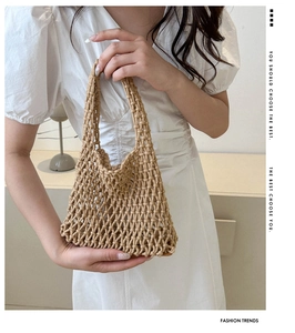Detail of handmade woven hollow mesh bucket bag in beige cotton rope for summer beach