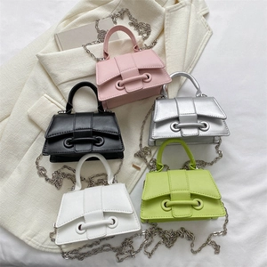 Mini PU leather chain bags in pink, silver, black, green and white on neutral fabric