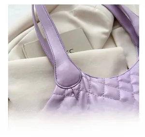 Close-up of purple quilted crossbody bag with detailed diamond stitching and leather texture