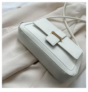 Vue détaillée du cuir blanc et de la boucle dorée sur le petit sac à main rectangulaire