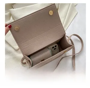 Vue intérieure montrant la capacité de ce petit sac bandoulière carré en feutre marron clair