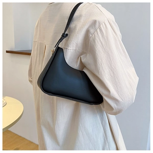Minimalist matte black shoulder bag with slim adjustable strap for women in detail view