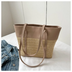 Detail of a dual-texture woven tote bag with brown leather top and straw bottom design