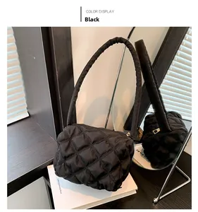 Detail of black quilted nylon shoulder bag with zipper closure and soft padded handle