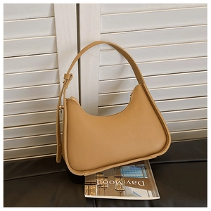 Detail view of khaki minimalist underarm bag featuring adjustable strap and smooth matte finish