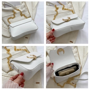 Detail of white moon-buckle shoulder bag with snakeskin texture and gold chain strap