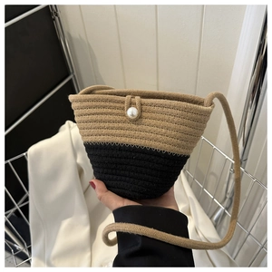 Detail of hand-woven bucket bag with pearl closure and dual-tone cotton rope texture