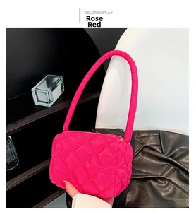 Detail of rose red nylon shoulder bag featuring quilted rhombic pattern and soft texture