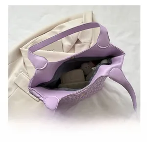 Top view of spacious purple quilted tote bag interior with cosmetics and accessories