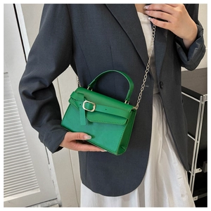 Detail of green leather square handbag with golden chain strap and buckle closure