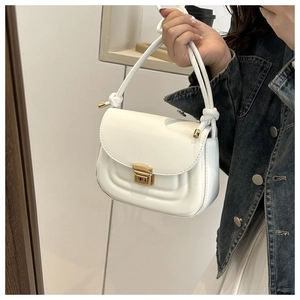 Detail of white faux leather crossbody bag with U-shaped stitching and golden clasp