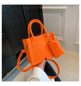 Detail of bright orange quilted felt tote bag with gold chain and matching pouch