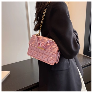Detail of metallic pink quilted handbag with gold chain strap and pleated handle detail