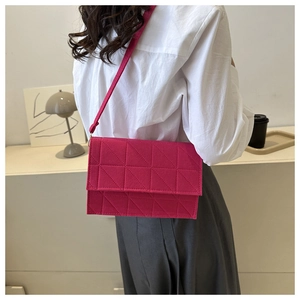 Sac bandoulière fuchsia matelassé avec motifs géométriques porté par un mannequin