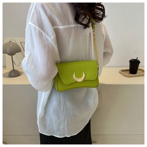 Detail of neon green snakeskin texture shoulder bag with gold crescent lock on model