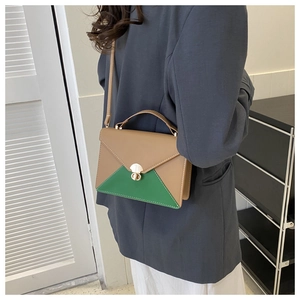 Detail of color-block envelope bag with green triangle patch and gold twist lock