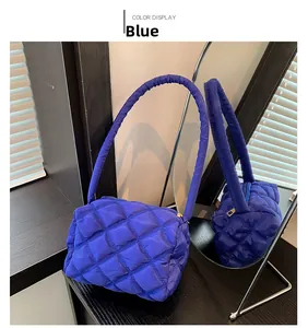 Detailed mirror reflection of the blue quilted nylon shoulder bag with cloud puffer texture