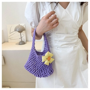 Detailed macro view of purple woven cotton mesh bag featuring yellow sunflower ornament