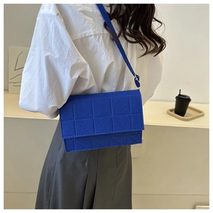 Détail du sac bandoulière en feutre bleu roi avec coutures géométriques matelassées
