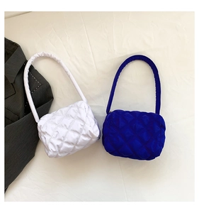 Close-up of quilted nylon shoulder bags in white and royal blue with diamond stitching