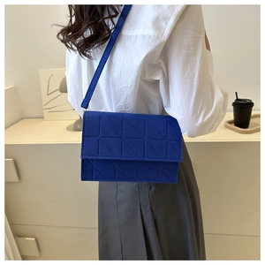 Détail du sac bandoulière en feutre bleu roi avec matelassage géométrique triangulaire
