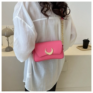 Detail of rose red crescent bag with snake pattern texture and gold crescent buckle