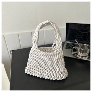 Detail of cream handmade woven cotton rope handbag with hollow mesh design for summer