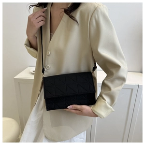 Détail d'un sac bandoulière en feutre noir au design minimaliste avec texture matelassée