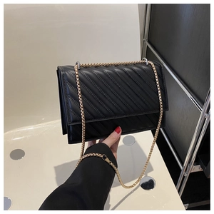 Dettaglio della borsa a tracolla in pelle nera trapuntata con catena dorata elegante