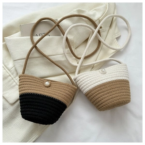 Detail of hand-woven straw bags with decorative pearl buttons and braided texture