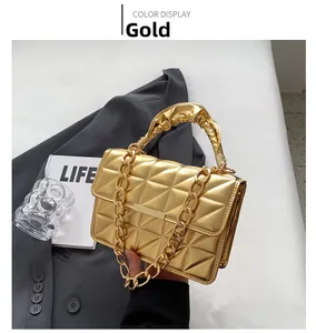 Detail of gold quilted mirror leather handbag with chain and ruched handle