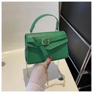 Detail of emerald green PU leather handbag with gold buckle and chain shoulder strap