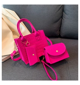 Close-up of three-piece fuchsia felt tote set with quilted texture on a stylish sofa
