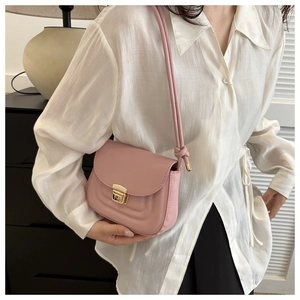 Pink leather shoulder bag detail with gold clasp and elegant knot strap decoration