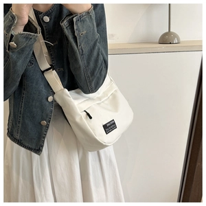 Detail shot of the durable white Oxford fabric texture and adjustable shoulder strap